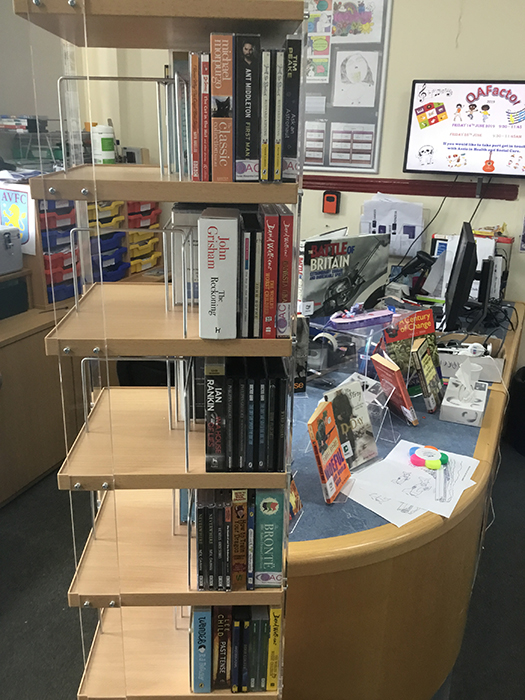 A bookshelf holding the donated audiobooks in the QAC library